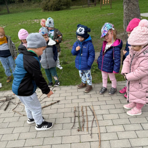 Dzieci porównują długości patyków.