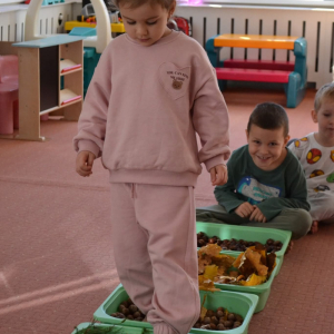 Spacer po jesiennej ścieżce sensorycznej, wykonanej z naturalnych materiałów.