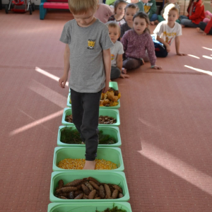 Spacer po jesiennej ścieżce sensorycznej, wykonanej z naturalnych materiałów.