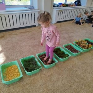 Spacer po jesiennej ścieżce sensorycznej, wykonanej z naturalnych materiałów.