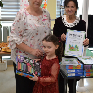 Dziewczynka odbiera nagrodę z rąk organizatorów konkursu.