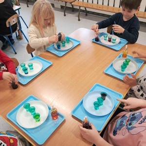 Dzieci uczestniczą w warsztatach naukowych.