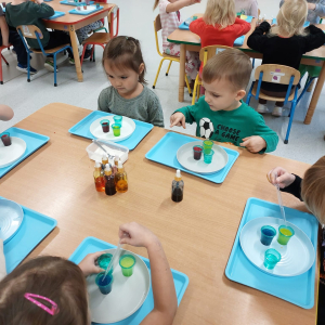 Dzieci uczestniczą w warsztatach naukowych.