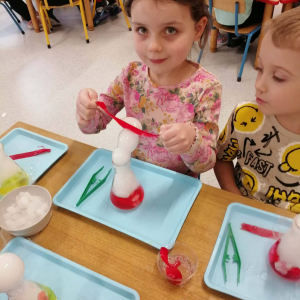 Dzieci uczestniczą w warsztatach naukowych.