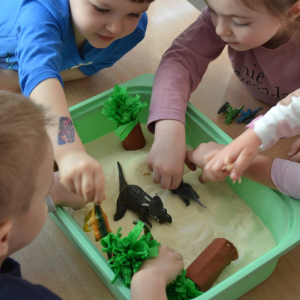 Sensoryczny Dzień Dinozaura- zabawy z kaszą.