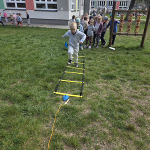 Przedszkolaki uczestniczą w zabawach sportowych.