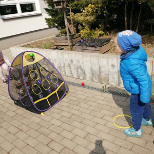 Przedszkolaki uczestniczą w zabawach sportowych.