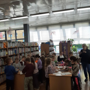 Dzieci biorą udział w lekcji bibliotecznej.