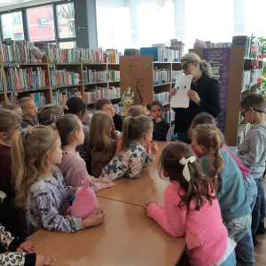 Dzieci biorą udział w lekcji bibliotecznej.