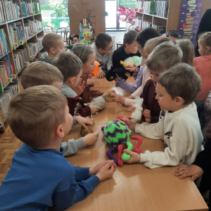 Dzieci biorą udział w lekcji bibliotecznej.