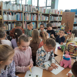 Dzieci biorą udział w lekcji bibliotecznej.